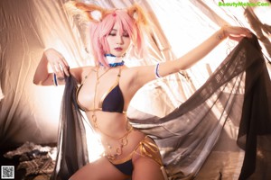 A woman in a bikini posing in front of a tent.