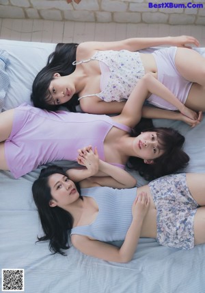 A group of young women sitting on top of a beach.