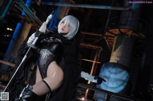 A woman in a black outfit holding a sword.