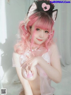 A woman with pink hair wearing a nurse outfit.