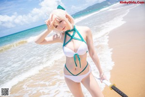 A woman in a bikini sitting on the beach.