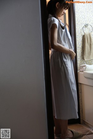 A woman wearing a blue and white striped dress.