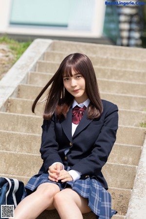 A woman in a school uniform posing for a picture.