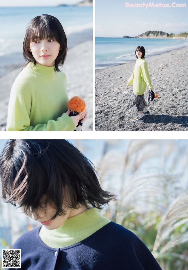 A woman in a green sweater standing on a beach.