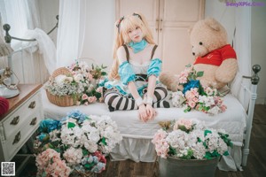 A woman sitting on the floor next to a bunch of flowers.