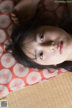 A woman laying on the floor looking at the camera.