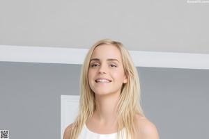 A nude woman with long blonde hair posing for the camera.