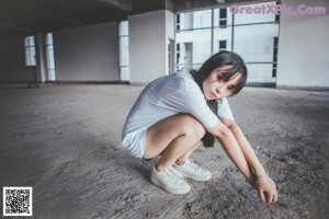 A woman in a white shirt and blue shorts posing for a picture.