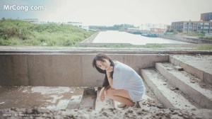 A woman in a gray shirt and white shorts posing for a picture.