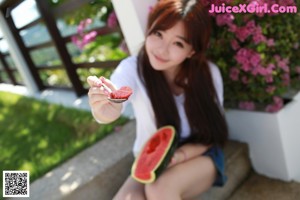 A woman sitting on the floor holding a glass of orange juice.