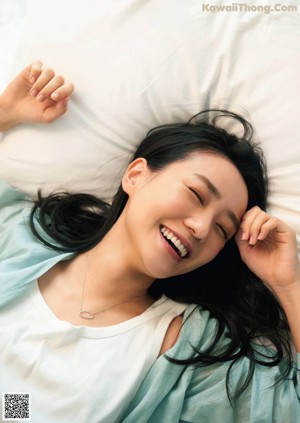 A woman laying on a bed with her legs up in the air.