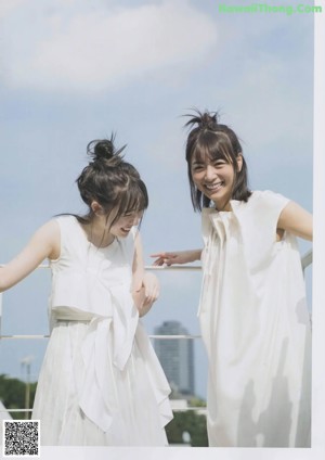 Two young women standing next to each other in white dresses.