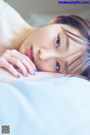 A woman laying on top of a bed with her legs up.