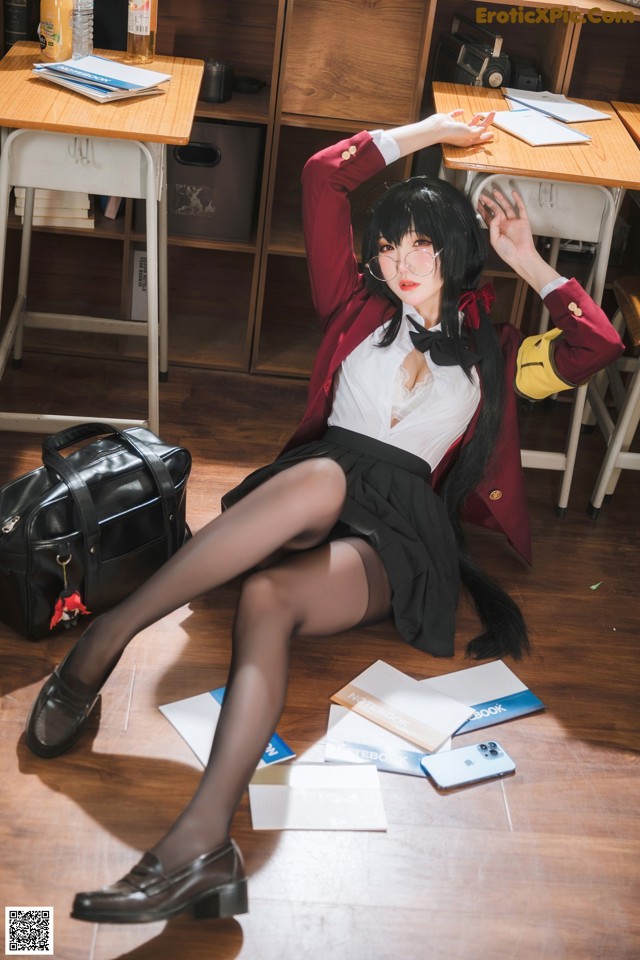 A woman sitting on the floor in a classroom.