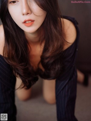 A woman in a black dress and hat laying on the floor.