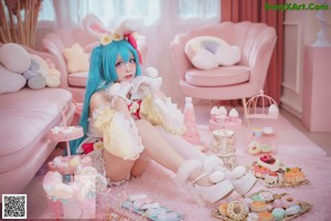 A woman with pink hair wearing a crown and holding a donut.