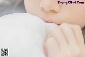 a woman laying on top of a bed in a white shirt