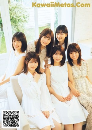 A group of young women laying on top of a bed.