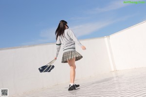 A woman in a school uniform posing for a picture.