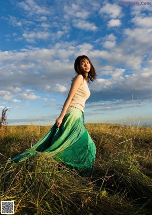 A young woman in a blue sweater posing for the camera.